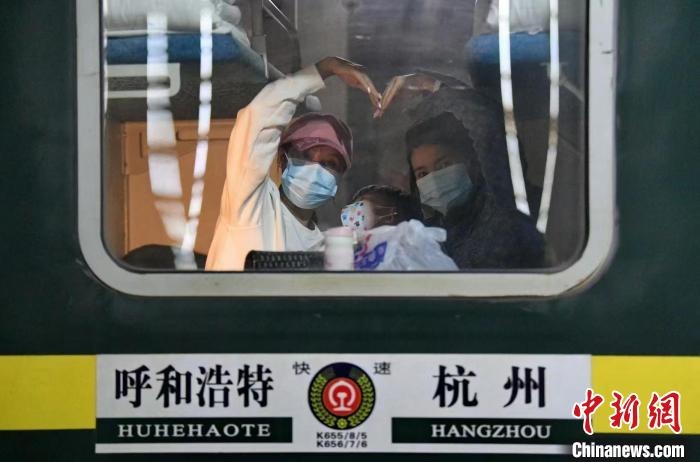 圖為登上轉(zhuǎn)運火車的游客向額濟(jì)納比心。　王磊 攝