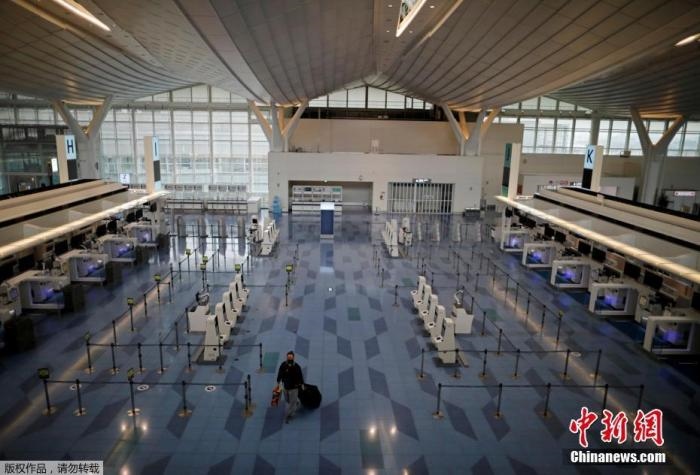 資料圖：日本東京，東京國際機場，一名乘客在國際航班航站樓的登機區(qū)。