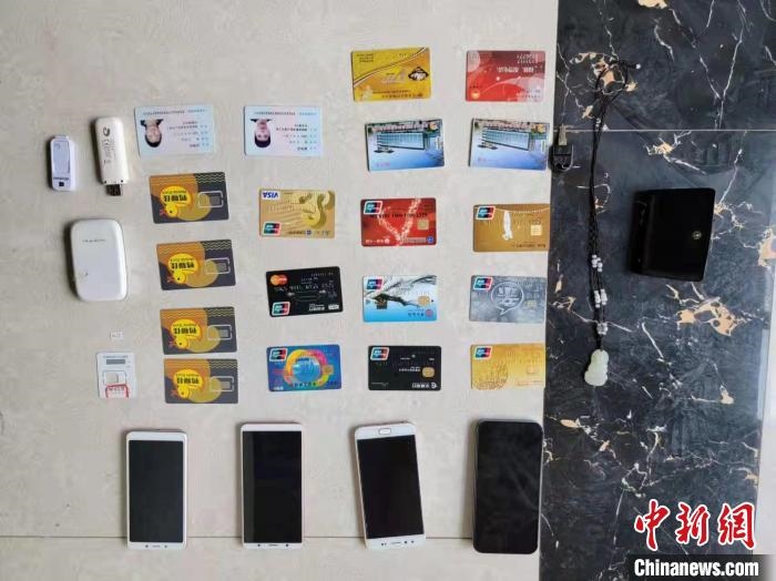 資料圖為果洛藏族自治州公安民警查扣的作案手機(jī)和涉案銀行卡?！‖斍呖h公安局供圖