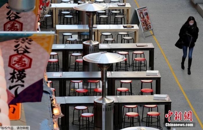 資料圖：日本東京，一名路人路過(guò)空蕩的戶(hù)外餐館。