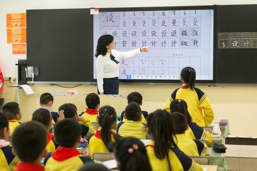 民族路小學（迎賓校區(qū)），語文老師燕凌云與學生們共同評議同學書寫的漢字.jpg