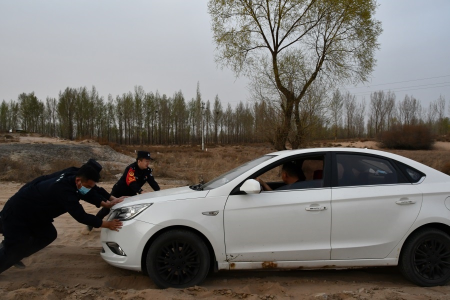 幫助群眾將陷入沙堆汽車(chē)推出.JPG