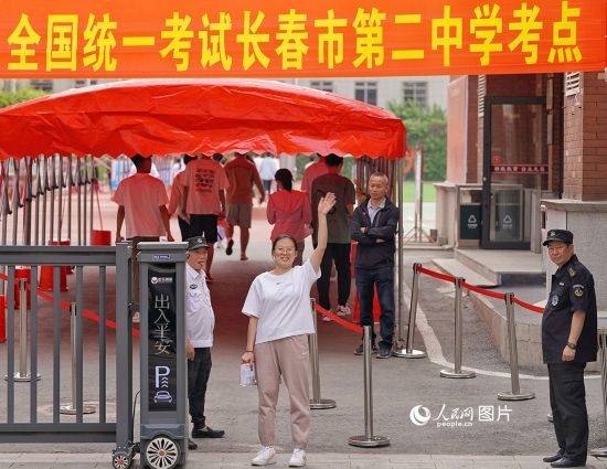 6月7日，在長春市第二中學(xué)考點(diǎn)，一名考生信心滿滿進(jìn)入考場，并與家長揮手致意。人民網(wǎng)記者 李洋攝
