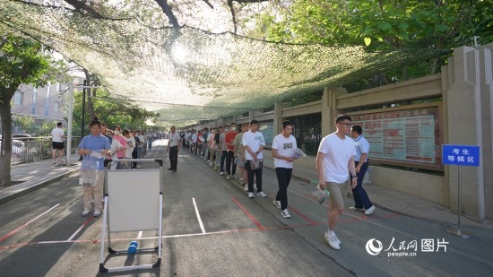 6月7日，烏魯木齊市第七十中學(xué)門口，考生們有序進(jìn)入考場。人民網(wǎng) 李欣洋攝