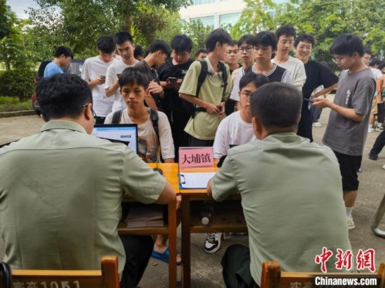 專武干部在發(fā)放兵役登記證。韋碩 攝
