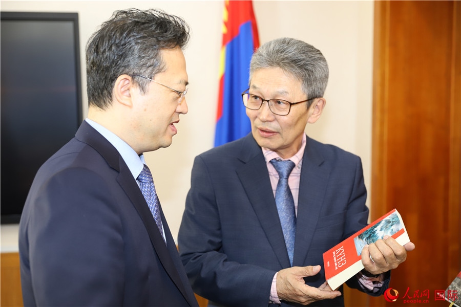 其米德策耶（右一）向李峙介紹翻譯成果。人民網(wǎng)記者 霍文攝