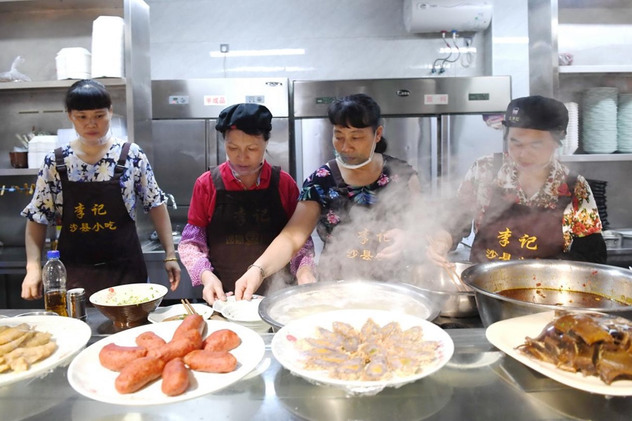 福建三明市沙縣區(qū)一家小吃店工作人員在為客人準(zhǔn)備特色小吃。 新華社記者 林善傳 攝