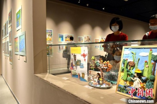 圖為家長帶著孩子參觀展覽。呂明 攝