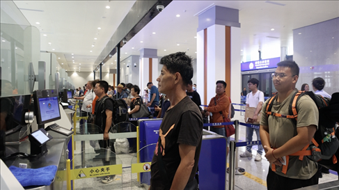 6月13日，乘坐中老鐵路國際旅客列車的旅客在磨憨邊檢大廳排隊(duì)候檢。李揚(yáng) 攝