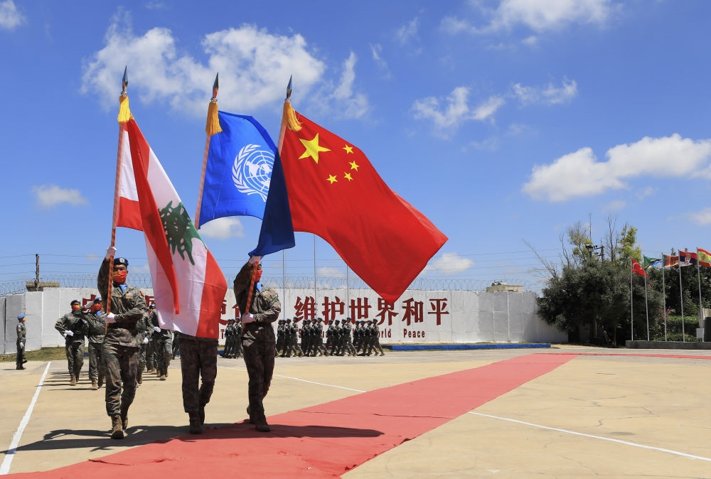 在黎巴嫩南部辛尼亞村的中國維和部隊營區(qū)，中國維和部隊官兵在受勛后通過觀禮臺（2022年7月1日攝）。聯(lián)合國駐黎巴嫩臨時部隊（聯(lián)黎部隊）當(dāng)日授予中國第20批赴黎巴嫩維和部隊全體410名官兵聯(lián)合國“和平勛章”，以表彰他們?yōu)槔璋湍勰喜康貐^(qū)和平穩(wěn)定作出的突出貢獻(xiàn)。新華社記者 劉宗亞 攝