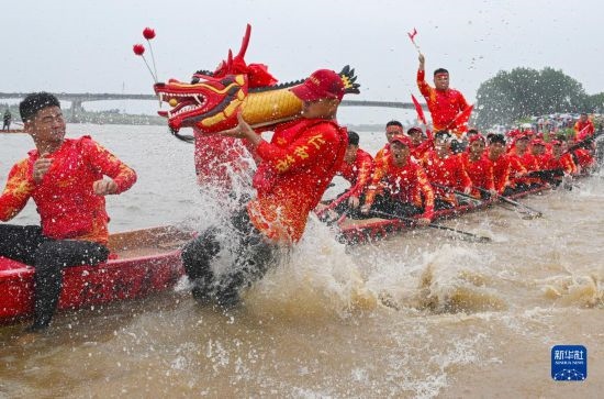 6月22日，在湖南省岳陽市湘陰縣湘江臨資口水域，參加龍舟賽的隊員接“龍頭”下水。
