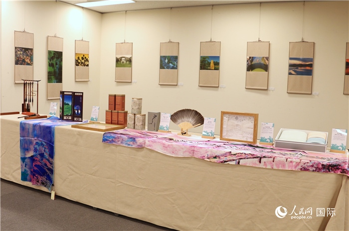 現(xiàn)場展出的馮學(xué)敏攝影作品與湖州市特色工藝品。（人民網(wǎng) 許可攝）