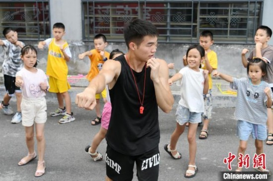 圖為大學(xué)生志愿者在組織孩子們參加體育健身活動(dòng)。廖光福 攝
