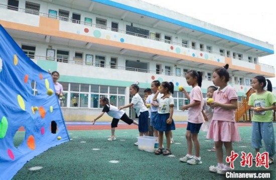 在肥西縣山南鎮(zhèn)中心幼兒園，孩子們在玩布洞投球游戲。陳家樂 攝