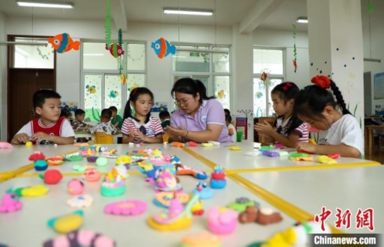 在肥西縣山南鎮(zhèn)中心幼兒園，孩子們在老師的指導(dǎo)下做彩色泥塑。陳家樂 攝