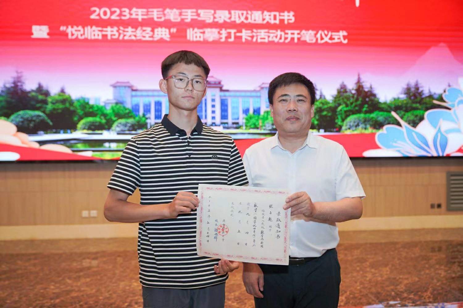 陜西師范大學(xué)黨委書記李忠軍為2023級新生代表張占彪同學(xué)發(fā)放錄取通知書。校方供圖