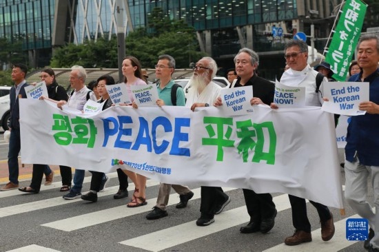 7月22日，在韓國首爾，人們手舉標(biāo)語參與反戰(zhàn)游行。新華社發(fā)（楊暢 攝）