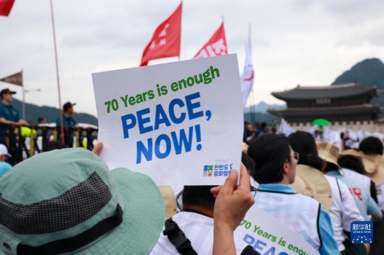 7月22日，在韓國首爾，人們手舉標(biāo)語參與反戰(zhàn)游行。新華社發(fā)（楊暢 攝）