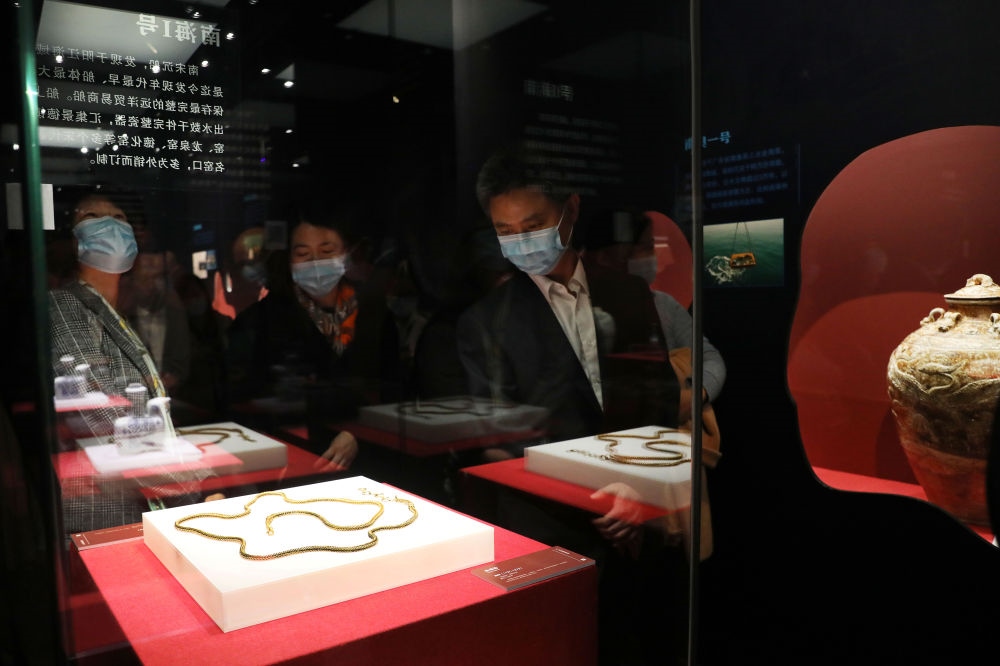 參觀者在上海臨港新城的中國航海博物館航海文物展上的“南海一號”出水的宋代金項飾展柜前駐足觀看（2020年12月28日攝）。新華社記者 方喆 攝