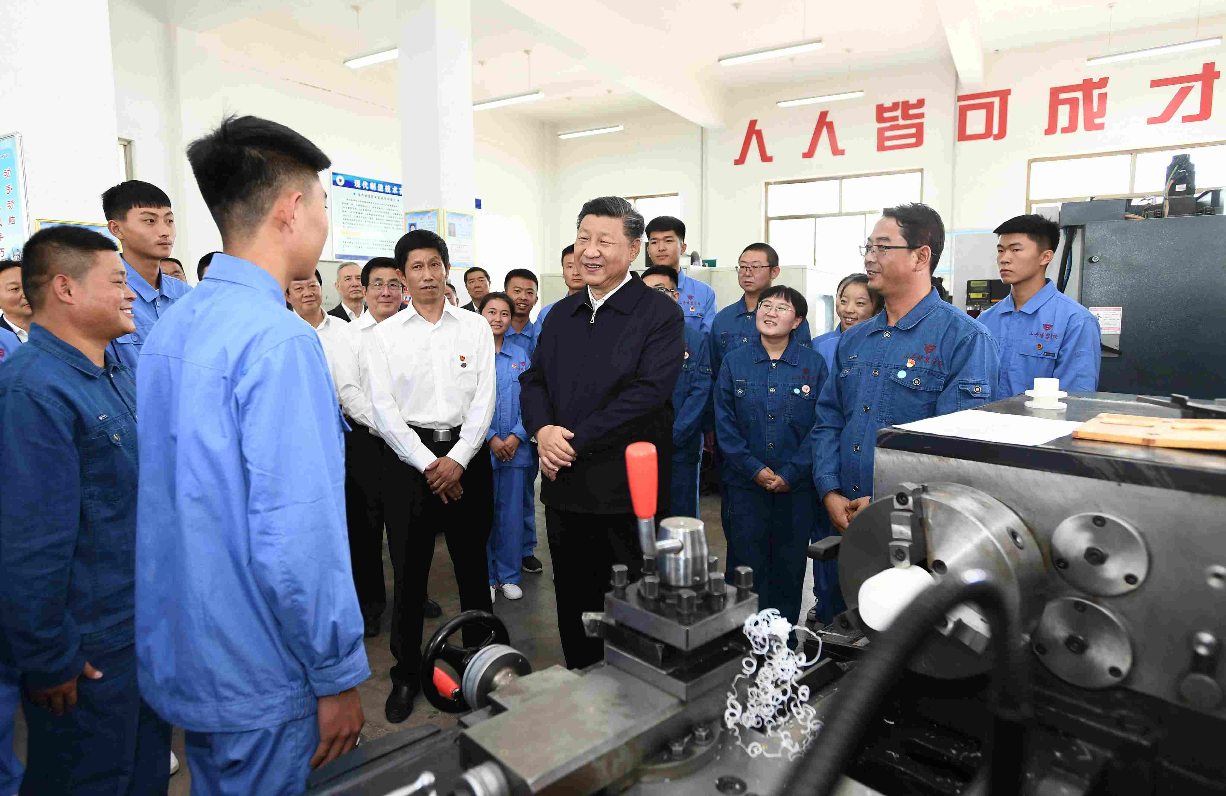 2019年8月20日，習(xí)近平在甘肅省張掖市山丹培黎學(xué)?，F(xiàn)代制造技術(shù)實(shí)訓(xùn)室，觀看職業(yè)技能實(shí)訓(xùn)，同師生親切交流。