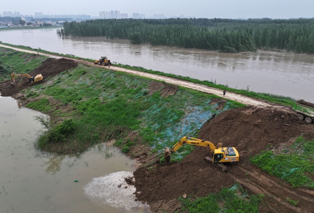 工人操作機(jī)械在白溝河左堤白溝新城高橋村段進(jìn)行除險加固作業(yè)（8月4日攝，無人機(jī)照片）。新華社記者 朱旭東 攝