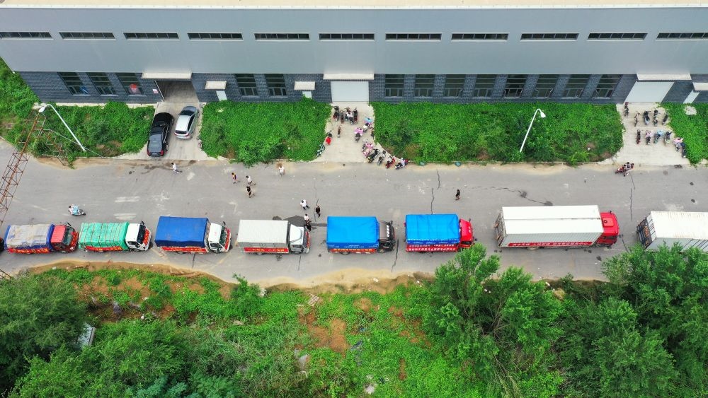 在河北省涿州市鋼研物資儲備點(diǎn)外，運(yùn)送物資的車輛排起長隊（8月5日攝，無人機(jī)照片）。新華社記者 牟宇 攝