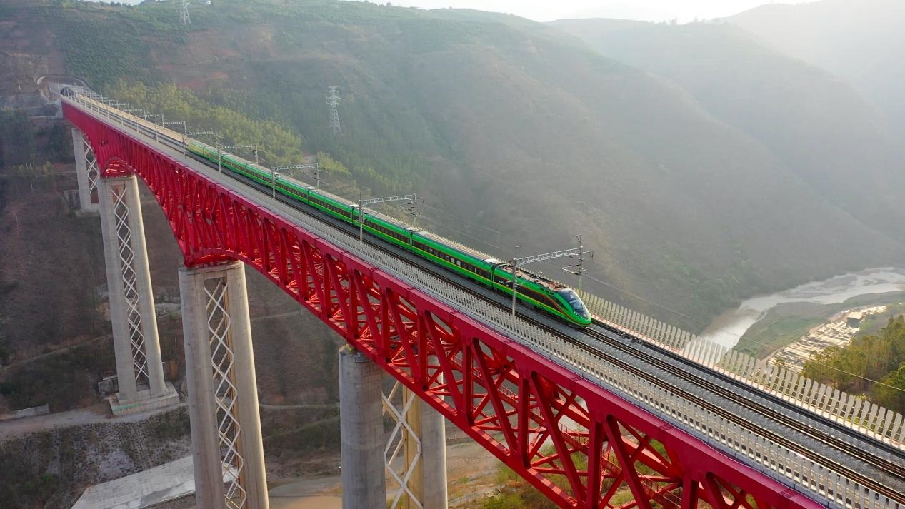 中老鐵路國際旅客列車在云南省境內(nèi)的元江特大橋上飛馳。姚巍攝