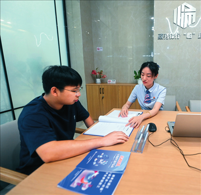 在杭州市臨安區(qū)政務(wù)服務(wù)中心的“為企服務(wù)中心”，黨員志愿者（右）解答企業(yè)主的疑問(wèn)（2023年7月7日攝）。徐昱攝/本刊