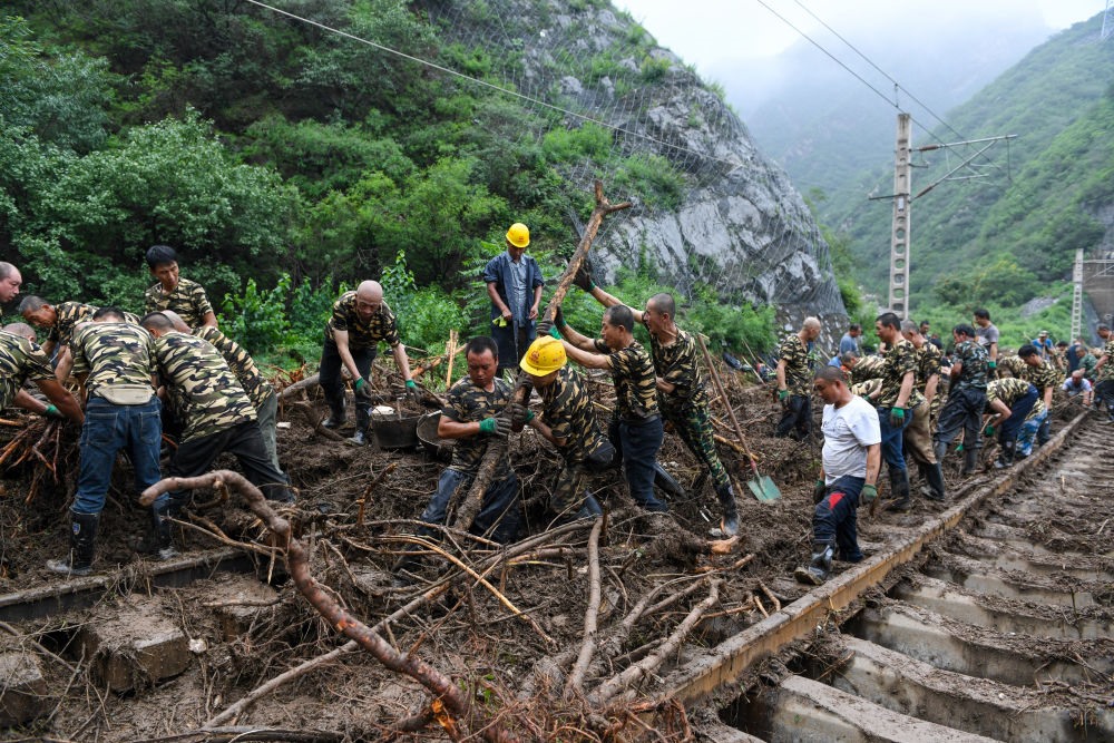 8月1日，在北京市門(mén)頭溝區(qū)水峪嘴村附近一段被阻斷的鐵路線(xiàn)上，中鐵六局工作人員在清理軌道上的雜物，全力恢復(fù)交通。新華社記者 鞠煥宗 攝