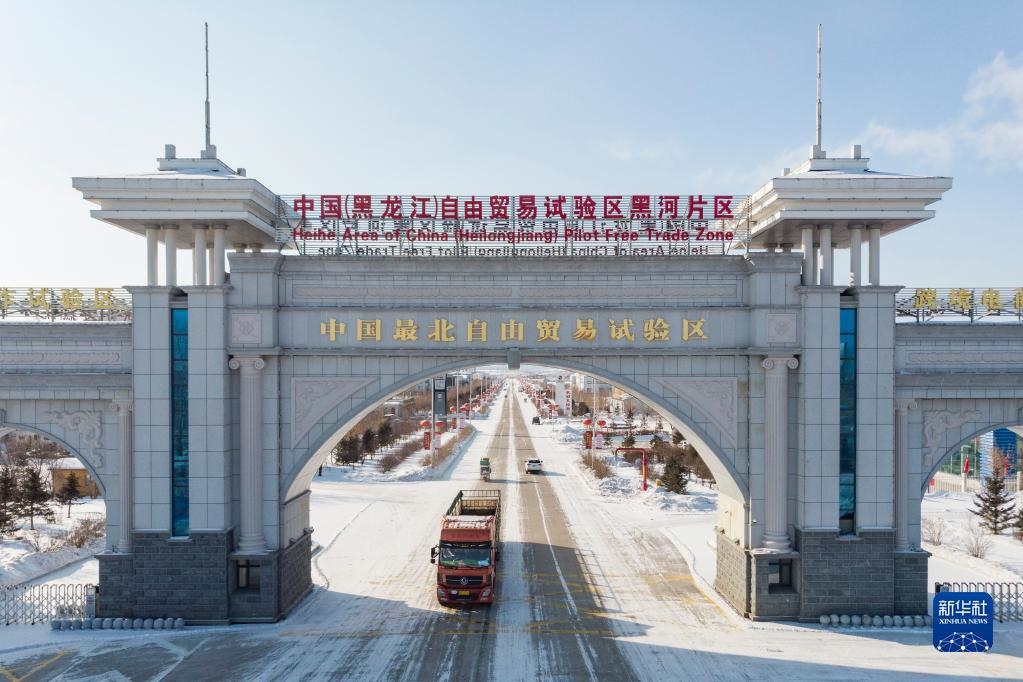 2月11日，車輛駛出中國(guó)（黑龍江）自由貿(mào)易試驗(yàn)區(qū)黑河片區(qū)大門（無(wú)人機(jī)照片）。新華社記者 謝劍飛 攝
