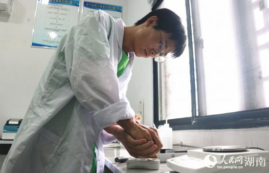 吳健筆在獼猴桃科技小院實(shí)驗(yàn)室測(cè)量水果糖分。 人民網(wǎng)記者 劉賓攝