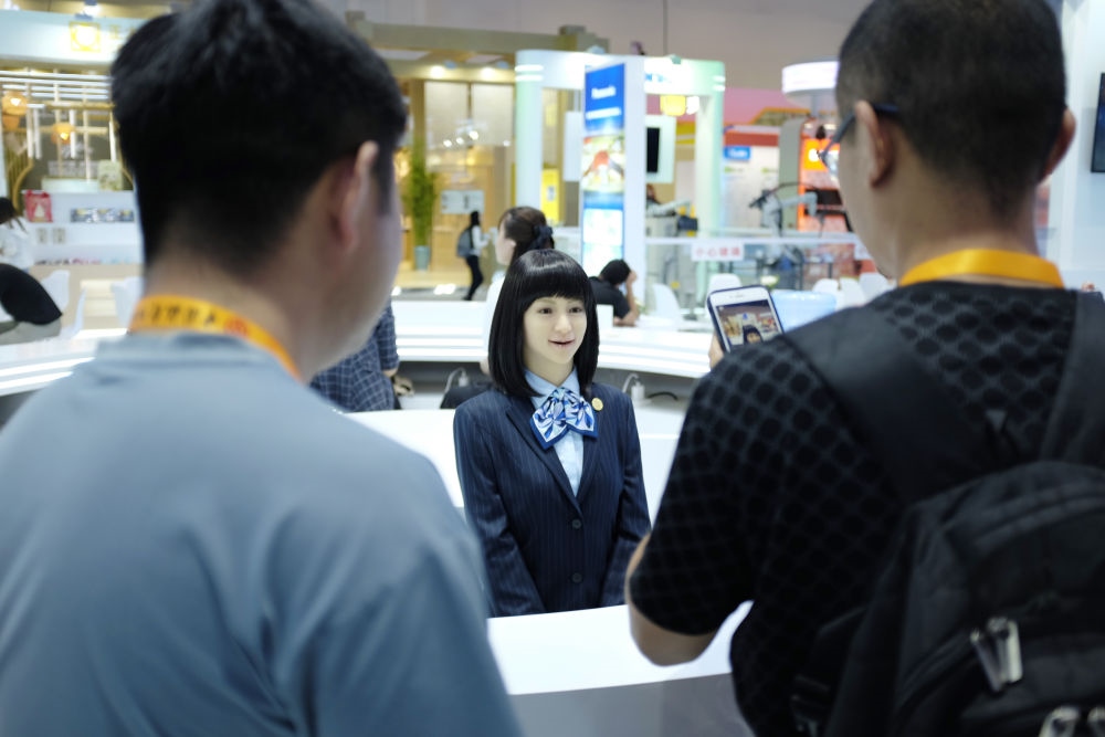 9月1日，媒體記者在國家會議中心與服務(wù)機(jī)器人互動。新華社記者 劉夢琪 攝