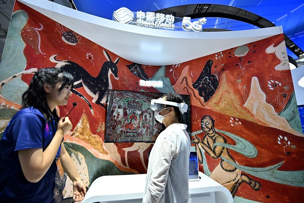 9月3日，一名參觀者在首鋼園中國移動(dòng)展臺(tái)體驗(yàn)基于AR/VR特效的敦煌導(dǎo)覽，沉浸式感受敦煌壁畫的魅力。新華社記者 李鑫 攝