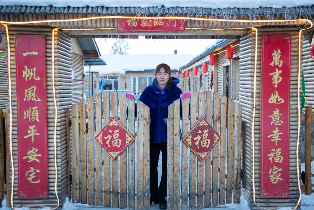 北極村民宿經(jīng)營者史瑞娟在門前迎候入住的游客（2023年1月7日攝）。