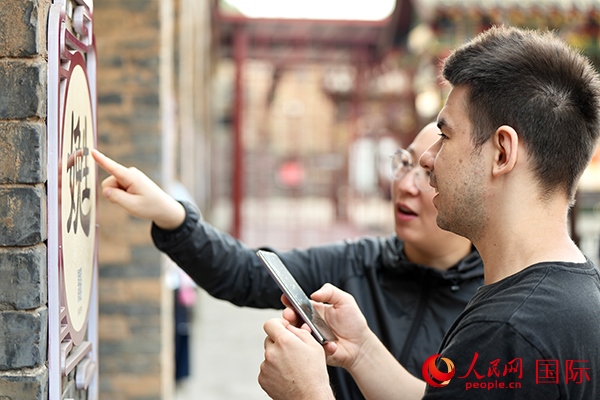 選手安德烈（俄羅斯）在老師指導(dǎo)下學(xué)習(xí)墻壁上張貼的生僻字。人民網(wǎng) 盧鵬宇攝