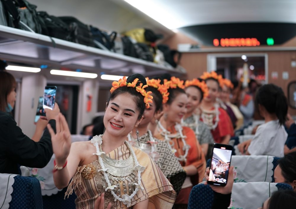 2023年4月13日，老撾工作人員在中老鐵路上開行的D887次國際旅客列車上表演。新華社記者 邢廣利 攝