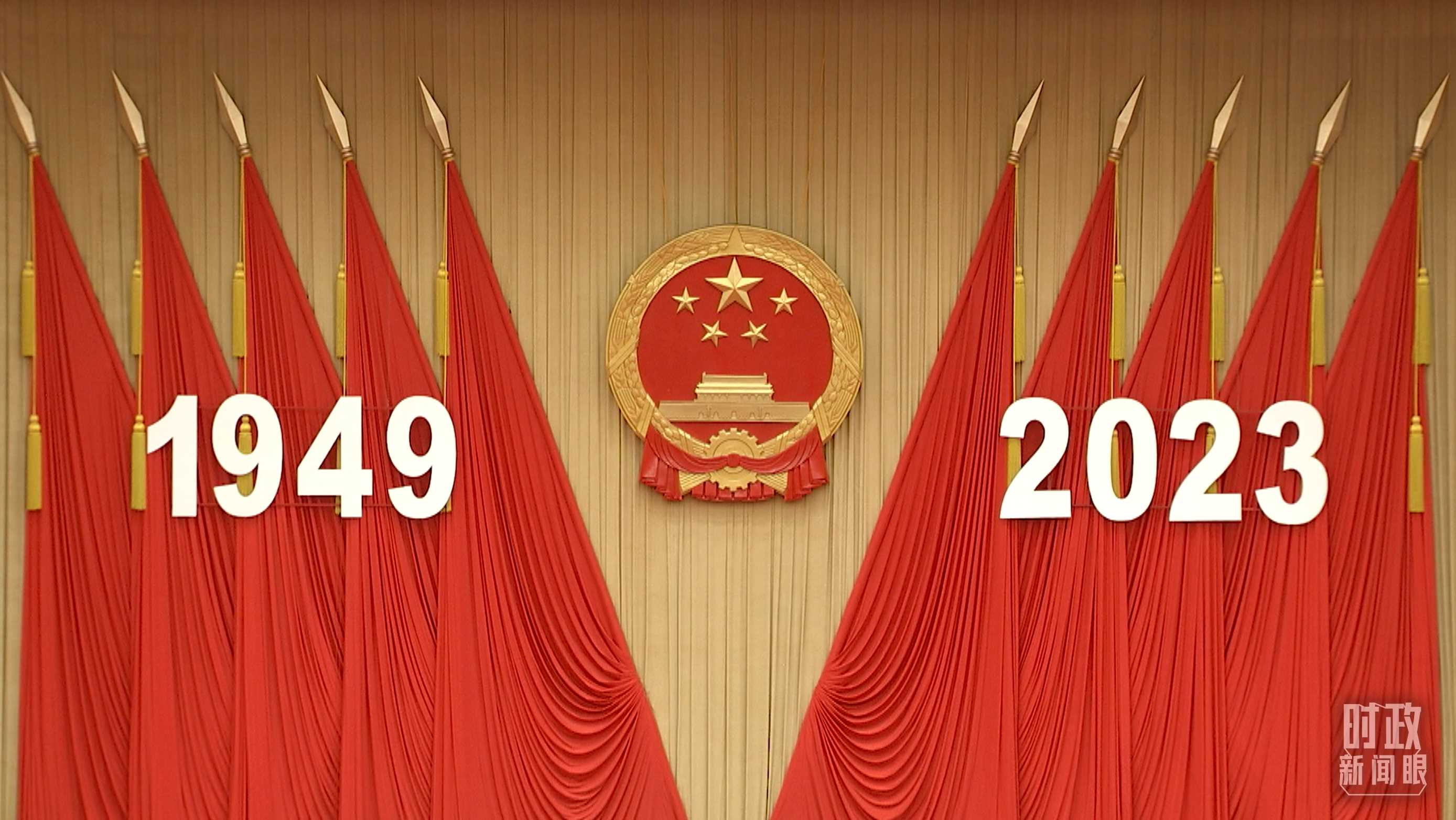 △人民大會(huì)堂宴會(huì)廳內(nèi)，主席臺(tái)上方高懸著莊嚴(yán)的國(guó)徽，“1949－2023”大字年號(hào)在鮮艷的紅旗映襯下格外醒目。