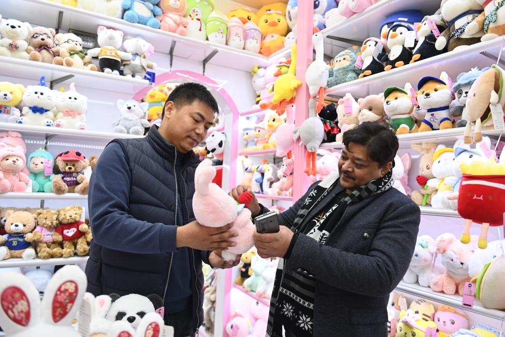 2023年2月2日，來(lái)自印度的客商（右）在義烏國(guó)際商貿(mào)城的一家玩具店鋪內(nèi)選購(gòu)商品。新華社記者 黃宗治 攝