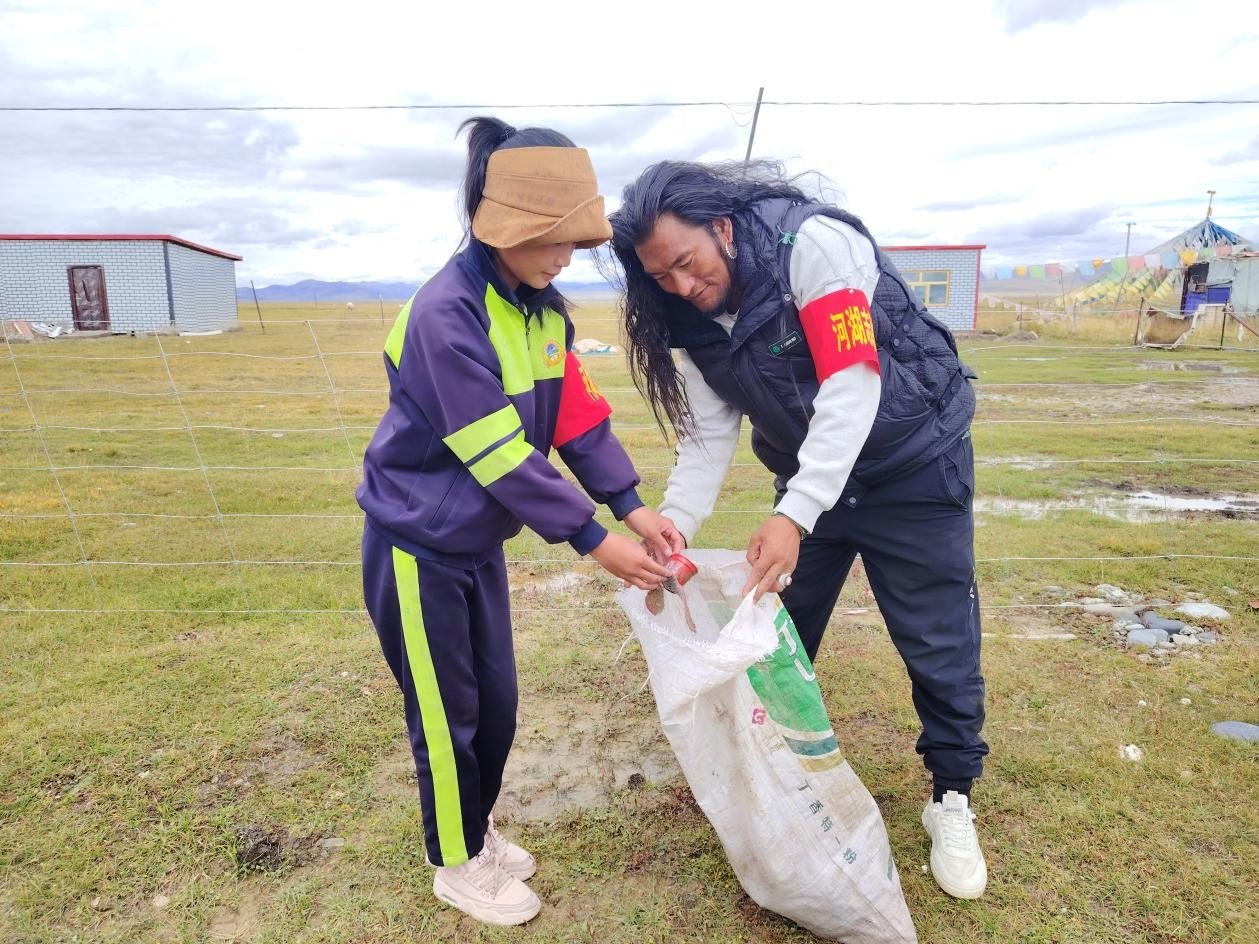 玉樹州稱多縣珍秦鎮(zhèn)河湖志愿者才培和他女兒更求拉毛在清掃垃圾。受訪者供圖