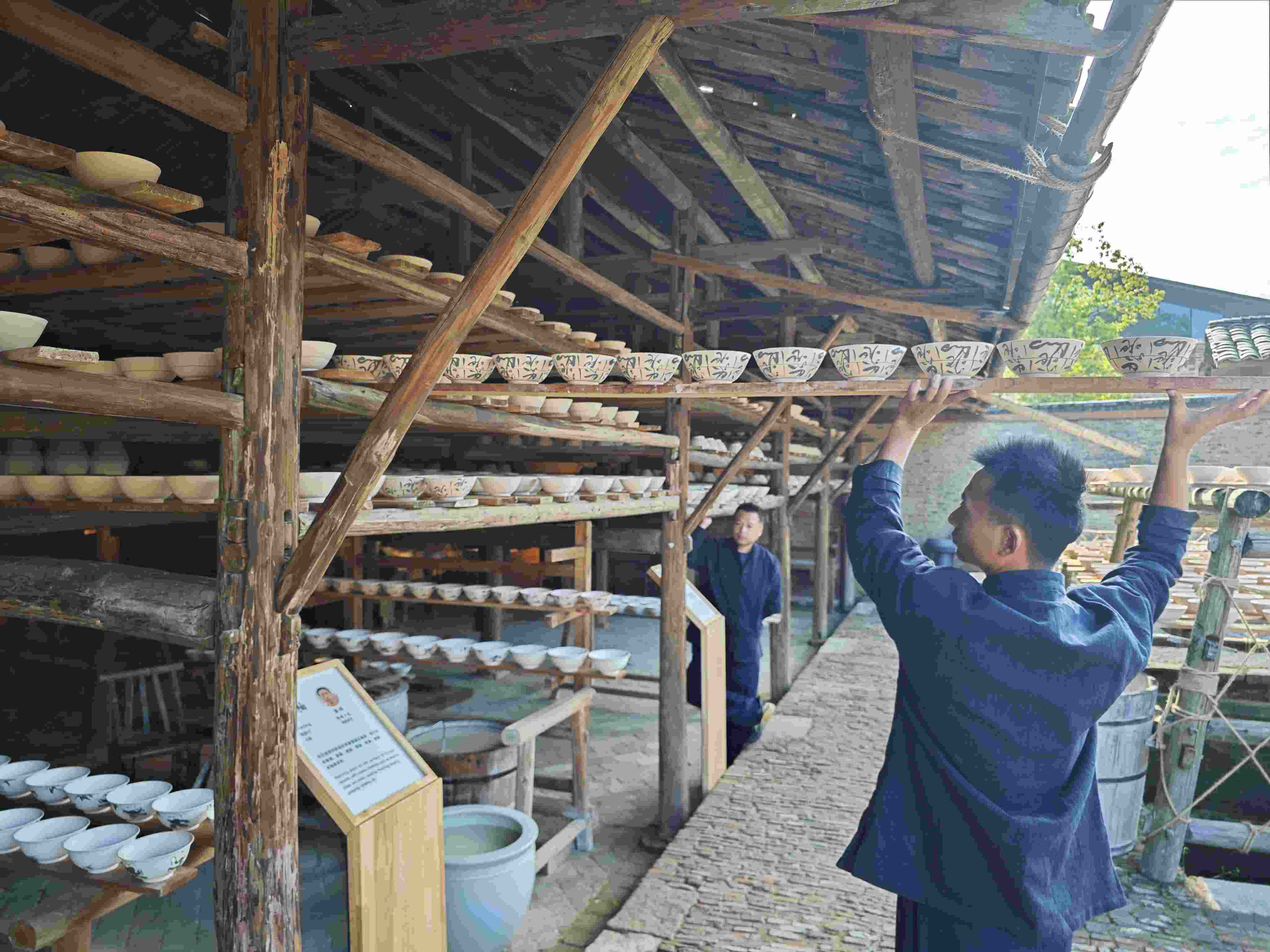 △陶陽(yáng)里歷史文化街區(qū)里，工匠將陶瓷工藝品放到架上晾干。（總臺(tái)央視記者彭漢明拍攝）
