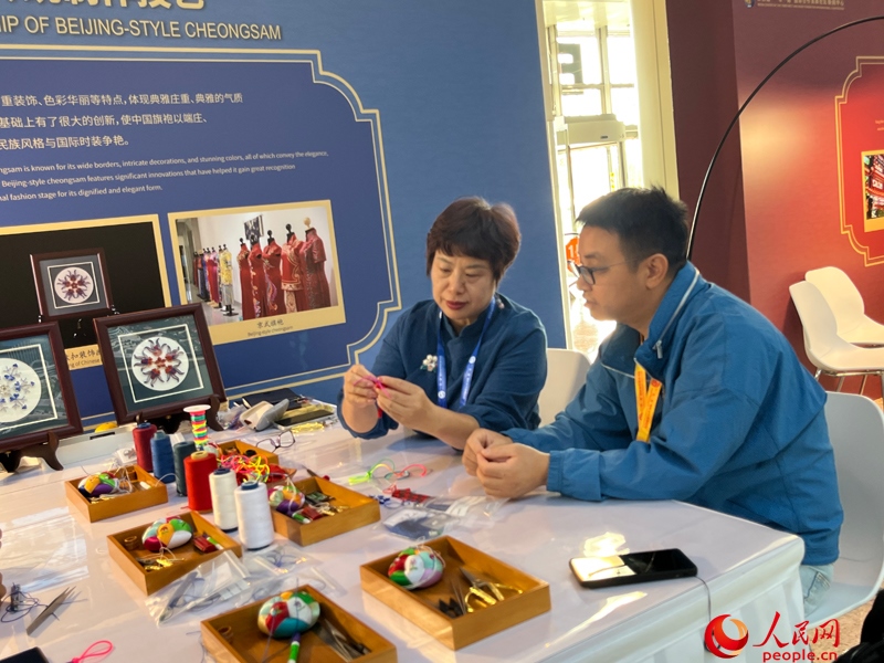 記者在新聞中心非遺傳承人展區(qū)進(jìn)行體驗(yàn)。人民網(wǎng)記者 杜燕飛攝