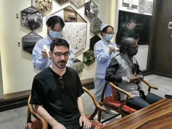 2023“一帶一路”媒體合作論壇聯(lián)合采訪(fǎng)團(tuán)團(tuán)員在九牛草展示館體驗(yàn)艾灸。（本報(bào)記者 黃超攝）