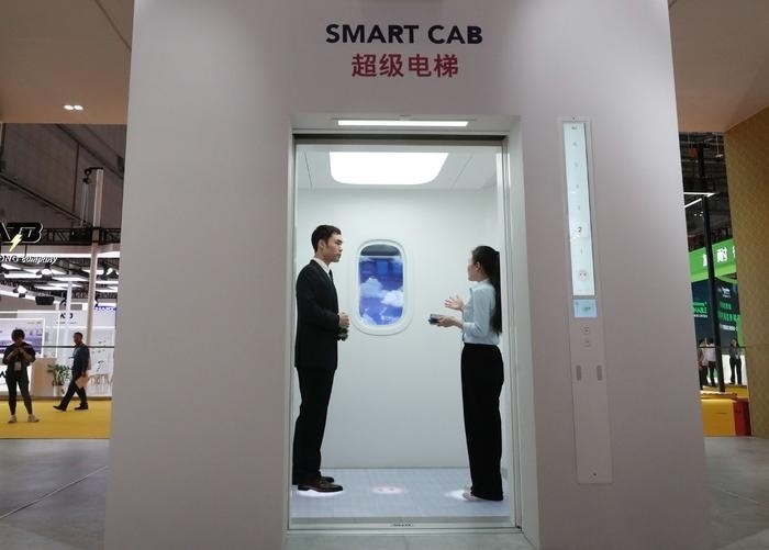 11月5日，工作人員（右）在第六屆進(jìn)博會(huì)上向參觀者介紹奧的斯公司全新推出的超級(jí)電梯。