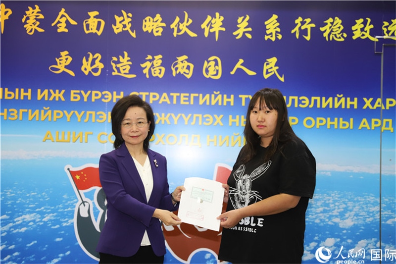 11月10日，沈敏娟大使向蒙古國(guó)公民尼亞姆庫(kù)（右）頒發(fā)最后一份領(lǐng)事認(rèn)證書(shū)。人民網(wǎng)記者 霍文攝