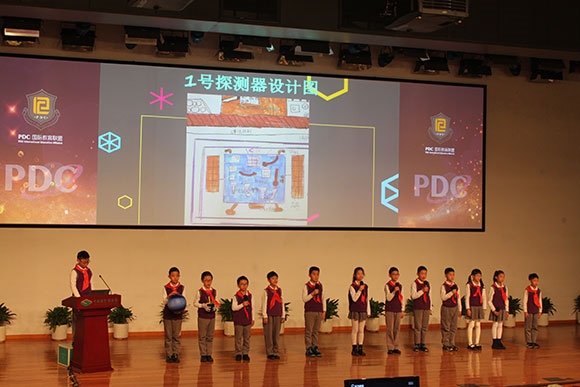 北京呼家樓中心小學(xué)的學(xué)生們展示PDC項目“新行星移民計劃探索衛(wèi)星設(shè)計”。