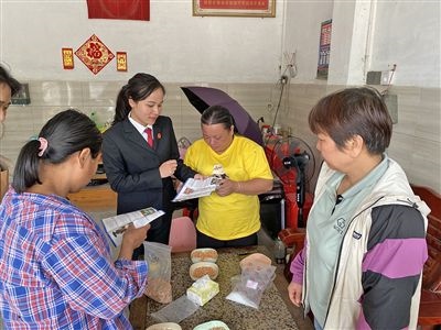  圖⑤：龍圩區(qū)法院法官到群眾家中開展法治宣傳。資料圖片