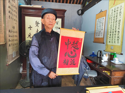 越南首都河內(nèi)文廟內(nèi)，阮明珠展示“中越心相近”書法作品。