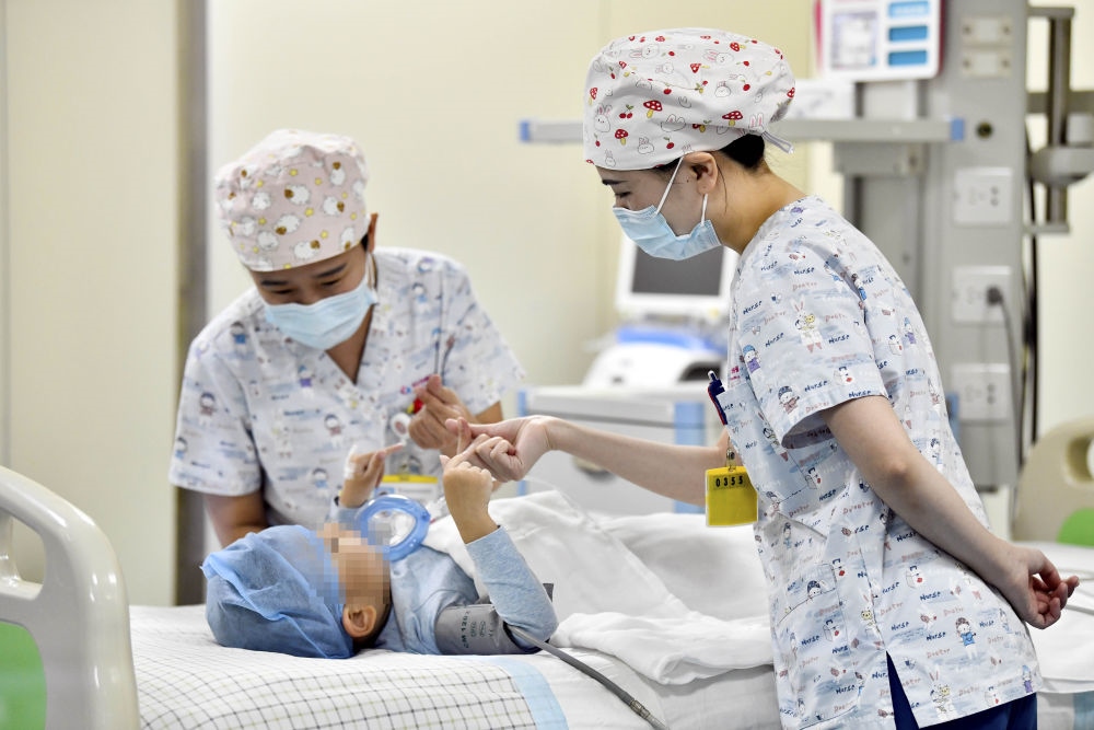 在山東省棗莊市婦幼保健院兒童ICU病房，醫(yī)護(hù)人員為完成靶向治療藥物諾西那生鈉的4歲脊髓性肌萎縮癥患兒加油鼓勁（2022年1月1日攝）。諾西那生鈉注射液是我國(guó)首個(gè)獲批治療脊髓性肌萎縮癥的進(jìn)口藥物，2019年進(jìn)入中國(guó)市場(chǎng)時(shí)，每針價(jià)格近70萬(wàn)元。在2021年國(guó)家醫(yī)保目錄藥品談判中，以3.3萬(wàn)元每針的價(jià)格進(jìn)入新版醫(yī)保藥品目錄。新華社記者 郭緒雷 攝