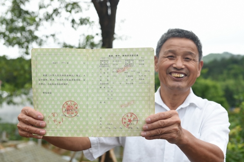 福建武平縣萬安鎮(zhèn)捷文村村民李桂林展示林權改革后領到的全國第一本新式林權證。