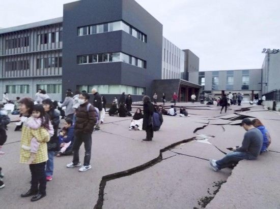  1月1日，在日本石川縣輪島市，人們站在被地震破壞的地面上。新華社/共同社